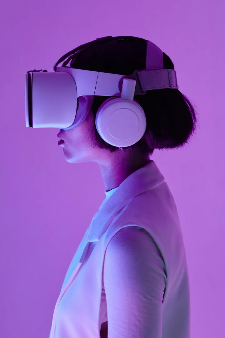 Femme de profil portant un casque de réalité virtuelle et un casque audio, fond violet, illustration des outils immersifs du métier de modeleur 3D
