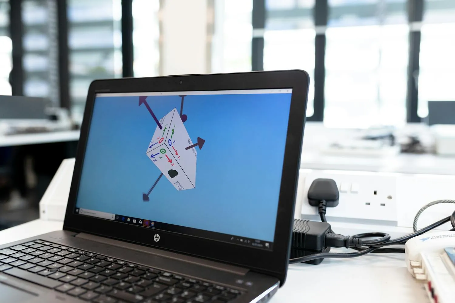 Ordinateur portable affichant un logiciel de modélisation 3D avec une pièce technique en cours de design